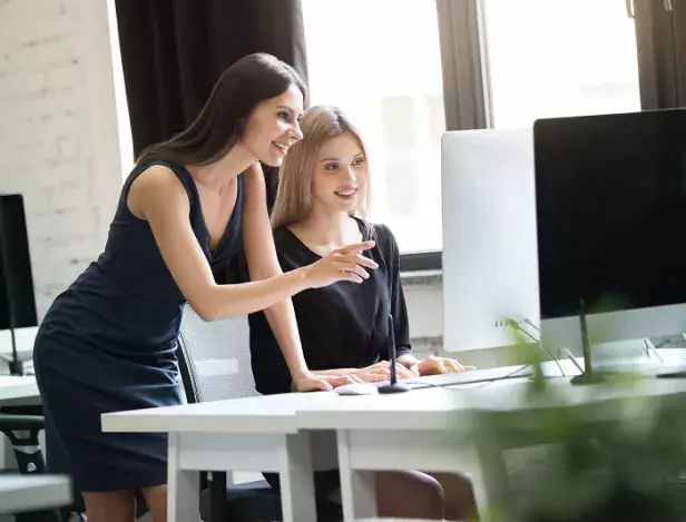 two-young-women-working-together-with-computer