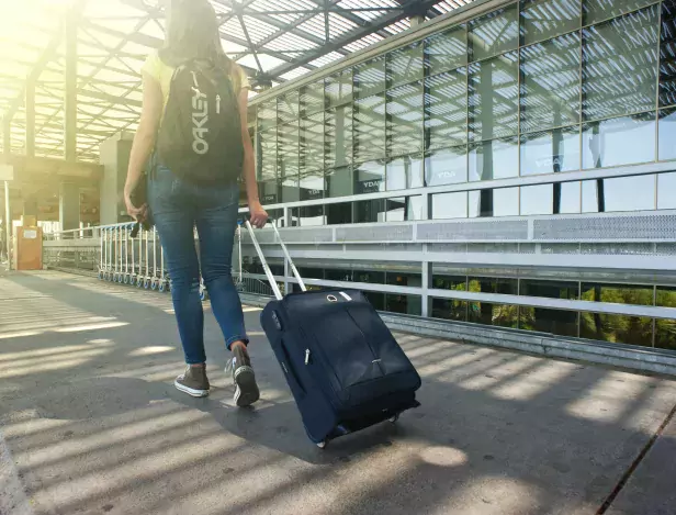 woman-walking-on-pathway-while-strolling-luggage-1008155-min-compressed